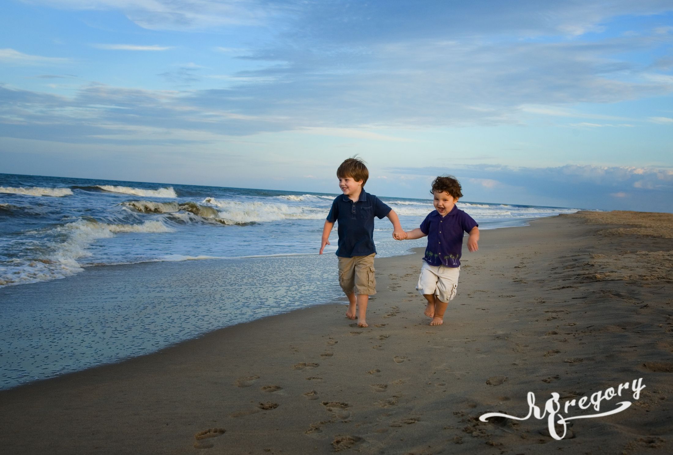 professional child photographer captures boys playing on beach